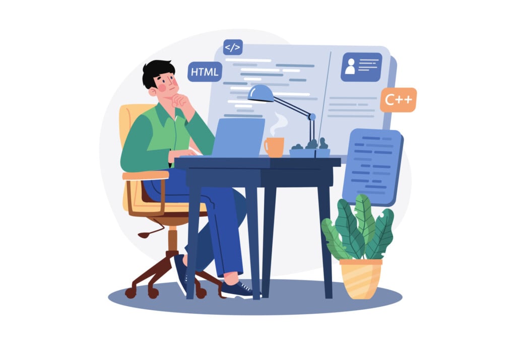 A programmer sitting at their desk working on a laptop